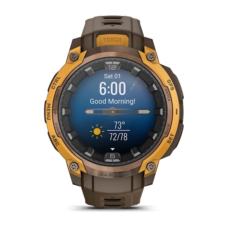 Garmin Instinct Crossover AMOLED smartwatch with brown strap and orange bezel, displaying time and weather.